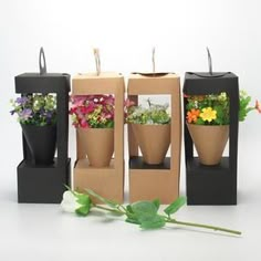 three vases with flowers in them sitting next to each other on top of boxes