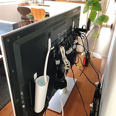 a computer monitor sitting on top of a desk with wires attached to the back of it