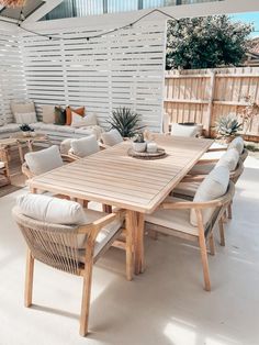 a wooden table sitting on top of a white floor next to a couch and chair