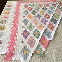 a quilted table runner with flowers on it