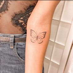 a woman's arm with a butterfly tattoo on the left side of her arm