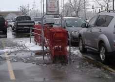 several cars parked on the side of a road covered in snow and ice as it's raining