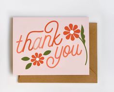 a pink thank you card with orange flowers and the words thank you written on it