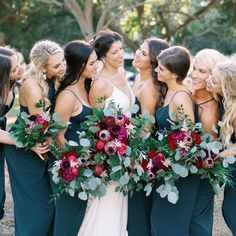 a group of women standing next to each other holding bouquets