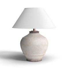 a white table lamp with a beige shade on the base and a light bulb attached to it