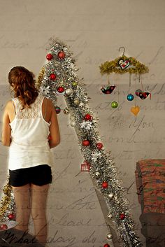 a woman standing in front of a christmas tree