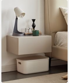 a nightstand with a lamp on it next to a bed