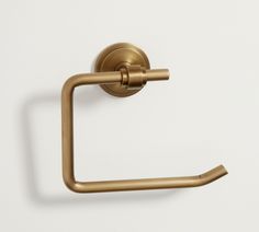 an antique brass toilet paper holder on a white wall, with the handle pointing upward