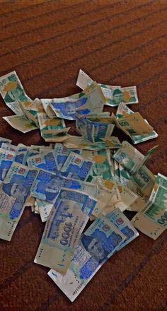 a pile of money sitting on top of a wooden floor