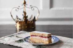 a piece of cake sitting on top of a plate next to a fork and a crown