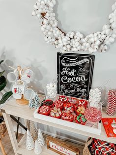 a table topped with lots of candy and christmas decorations next to a chalkboard sign