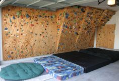 there are two mattresses in front of the climbing wall