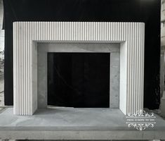 a white marble fireplace in a room with black walls