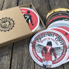 six beer coasters in a box on a wooden table