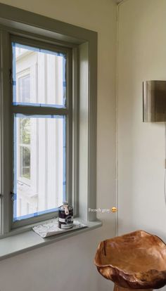 a wooden chair sitting in front of a window