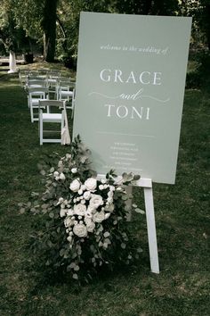 a sign that says grace and toni next to some white chairs in the grass