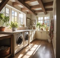 a washer and dryer in a room with wooden beams on the ceiling next to windows