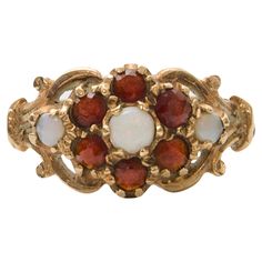 Step into the allure of history with this antique Edwardian 9 karat yellow gold halo ring, hailing from England. Adorned with the mesmerizing hues of opal and the deep richness of garnet, this ring is a testament to timeless beauty and sophisticated craftsmanship. Each stone is carefully set within the halo design, creating a harmonious blend of colors that dance with every movement. The opal, with its iridescent play of color, captures the essence of ethereal beauty, while the garnets add a tou Bohemian Style Rings, Gold Halo Ring, Medieval Rings, Antique Jewelry Rings, Halo Design, Nail Jewelry, Gold Halo, Ethereal Beauty, Halo Ring