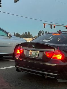 two cars stopped at an intersection with traffic lights