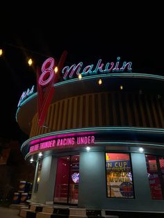 the neon sign on the building says 8pm and is lit up at night time