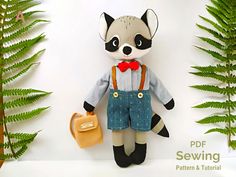 a stuffed raccoon is wearing overalls and holding a handbag in front of some ferns