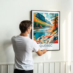 a man is hanging a poster on the wall