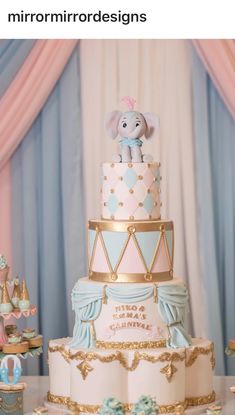 there is a three tiered cake with an elephant on top and other decorations around it