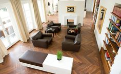 an aerial view of a living room with couches, bookshelves and fireplace