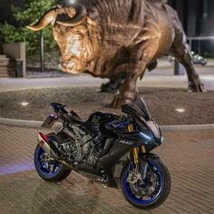 a motorcycle parked next to a statue of a bull