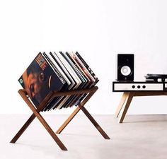 a stack of records sitting on top of a wooden stand next to a record player