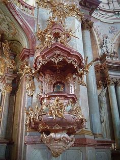 an ornately decorated wall in a church with gold and red decorations on the walls