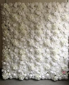 white flowers are arranged on the wall in this photo