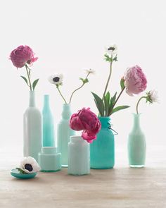 several vases with flowers in them sitting on a table