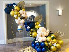 the balloon arch is decorated with blue, gold and white balloons