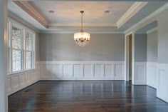 empty room with chandelier and hard wood floor