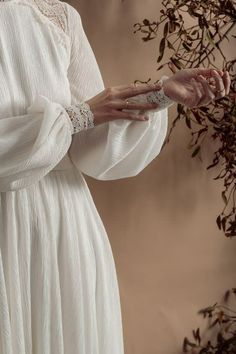 a woman in a white dress holding out her hand