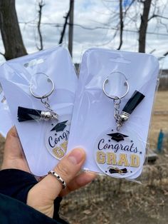 two keychains that say congrats grad and graduation caps on them