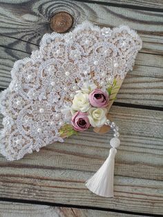 a bouquet of flowers on top of a white lace doily with pink and white roses