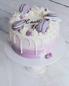 a cake with purple and white icing sitting on top of a table