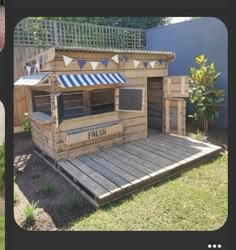 an outdoor food stand made out of pallets and wooden planks with awnings