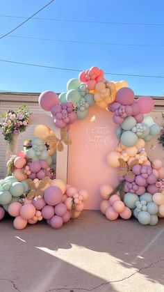 balloons and flowers decorate the entrance to a birthday party