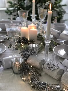 the table is set with silver dishes and candles