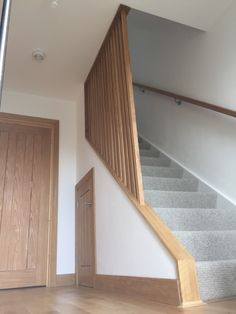 an empty room with stairs and wooden doors