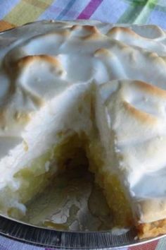 a lemon meringue pie with one slice cut out on a cake platter