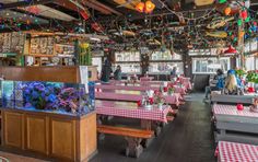 the inside of a restaurant with red and white checkered tablecloths on tables