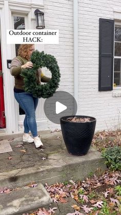 a woman holding a wreath in front of a house with the words outdoor container hack