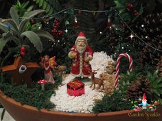 a potted planter filled with christmas decorations and santa clause sitting on top of it