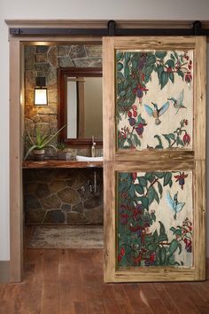 an open door leading to a bathroom with stone wall and wood flooring in it