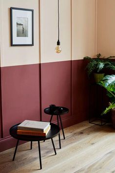 a table with a book on it next to a potted plant in a corner