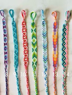 five different colored ropes are lined up in a row on a marble counter top, with one knoted at the end